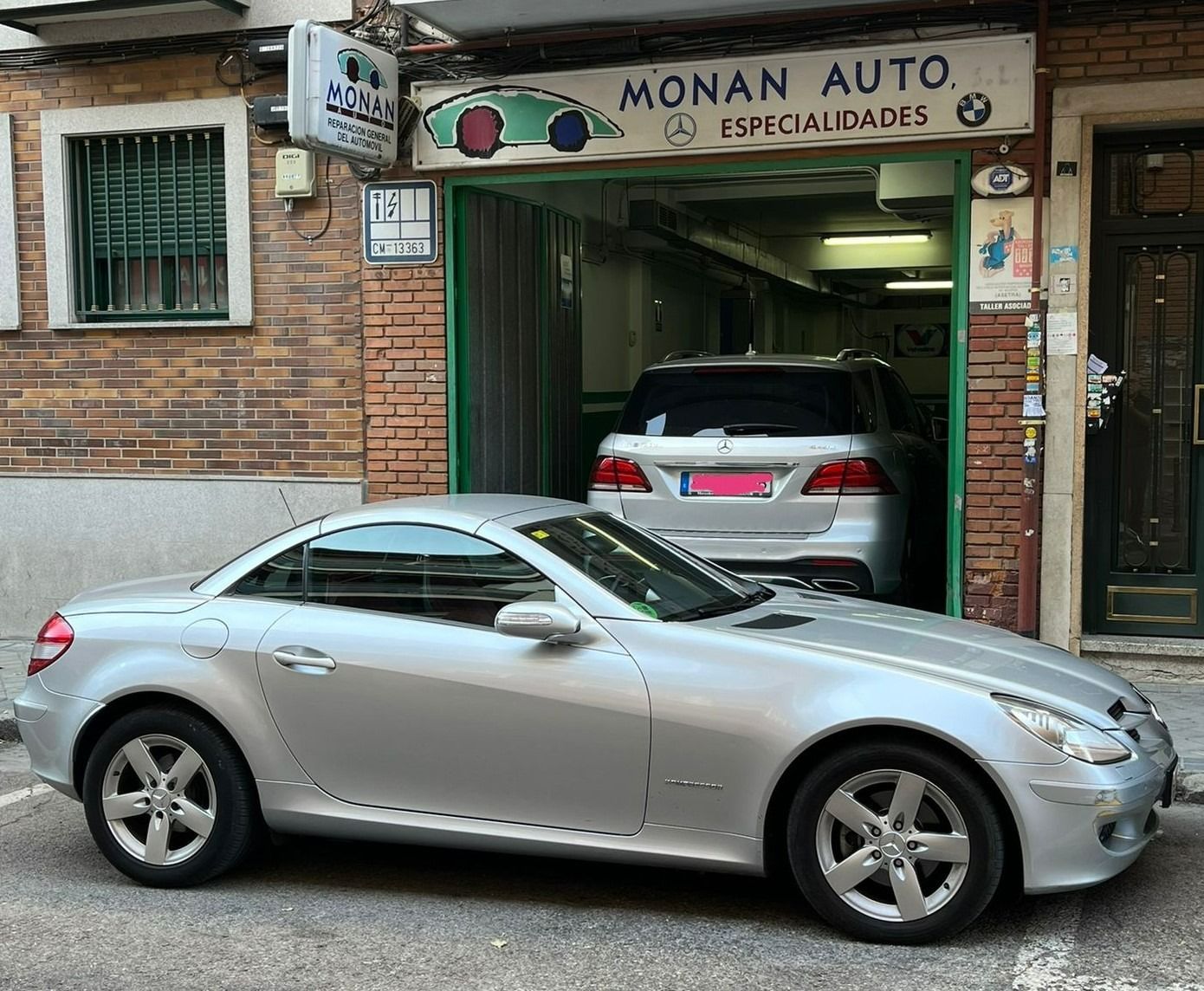 Un coche plateado está aparcado delante de una tienda llamada Monan Auto.