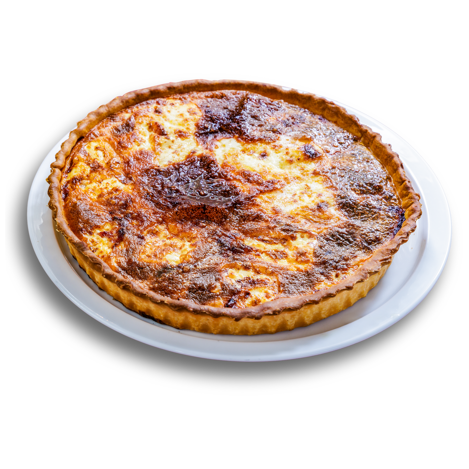 Une quiche dorée à la croûte cannelée, servie sur une assiette blanche.