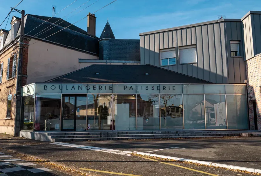 Un assortiment de viennoiseries fraîchement préparées et un cookie aux pépites de chocolat, servis sur une ardoise en pierre noire.