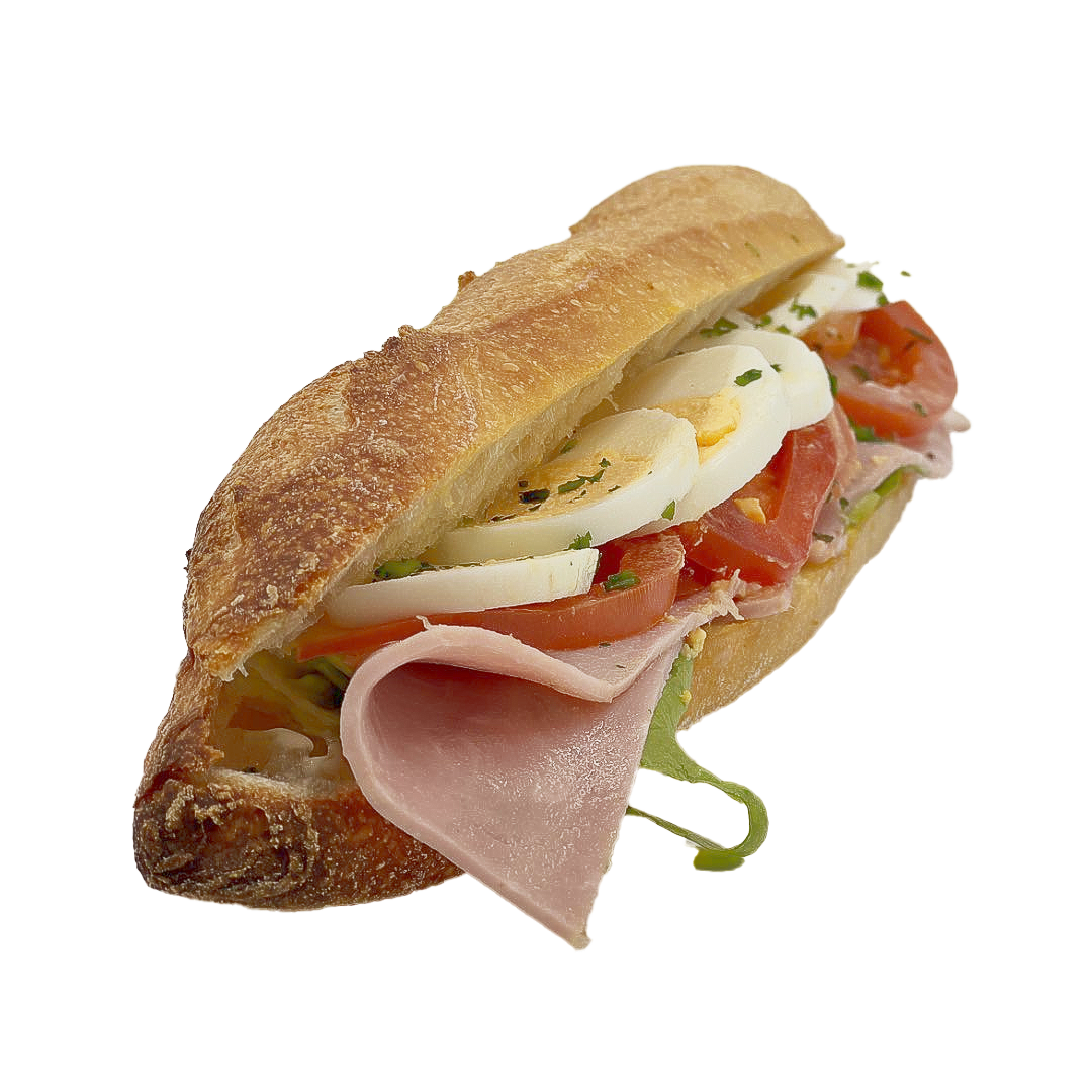 Un sandwich baguette croustillant garni de jambon tranché, d'œufs durs, de tomates fraîches et de laitue verte sur fond blanc.
