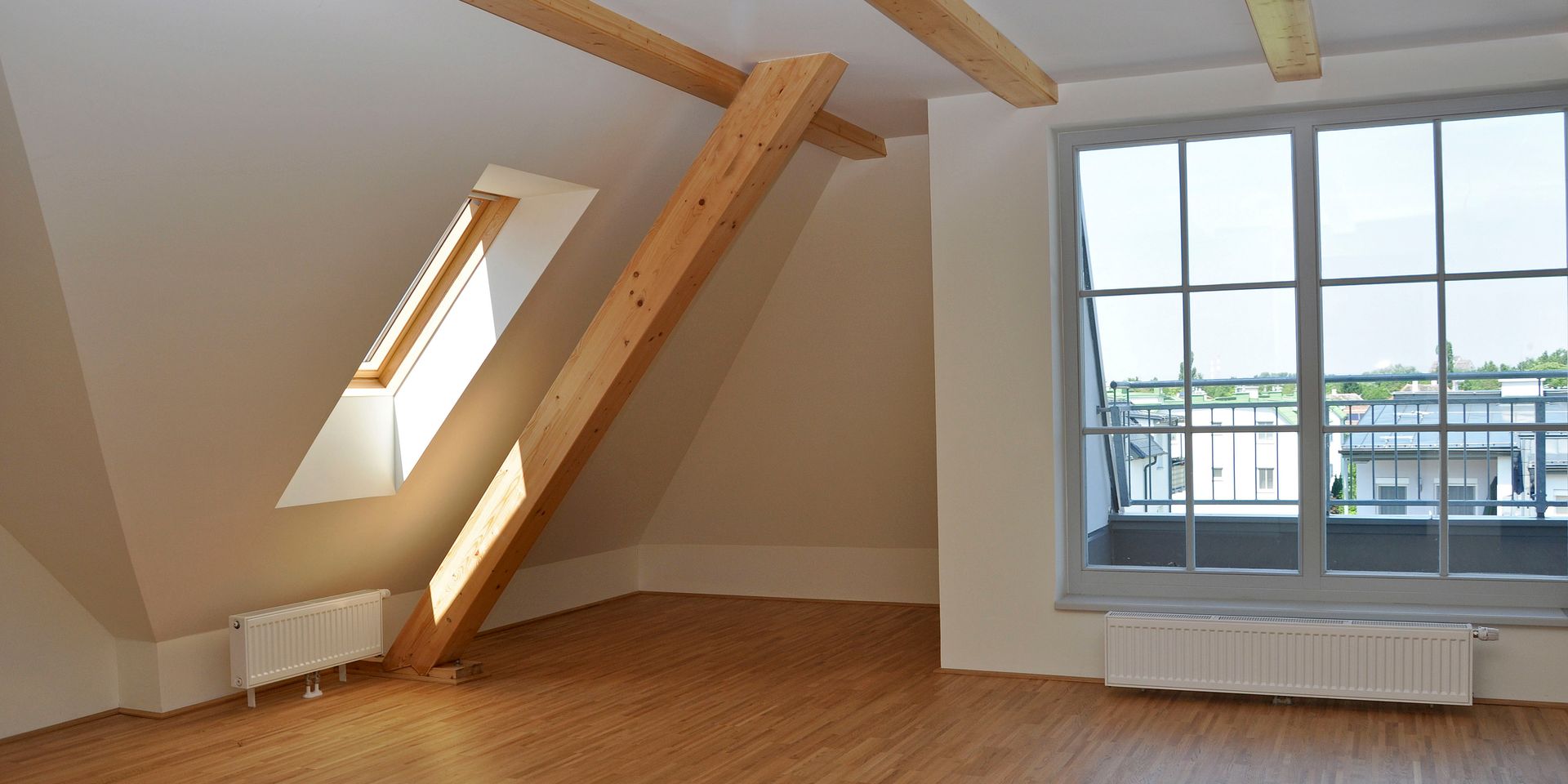 ein leerer Raum mit einem Fenster und einer Holztreppe