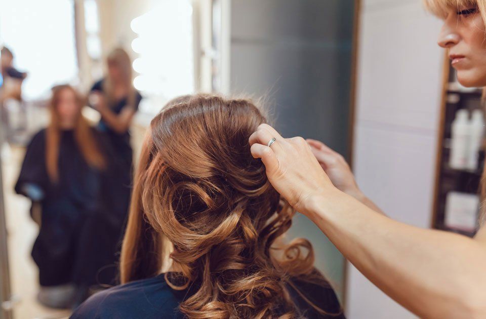 Artigiani Hairgroup – eine Frau bekommt eine Hochsteckfrisur