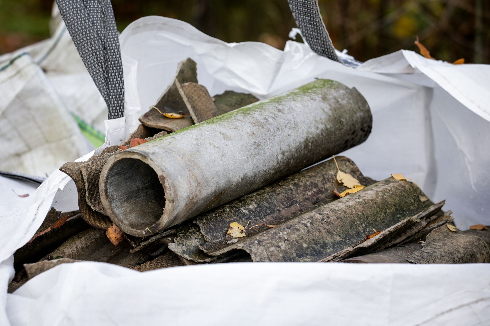 Débris d'amiante dans un sac blanc pour déchets ; vue rapprochée.