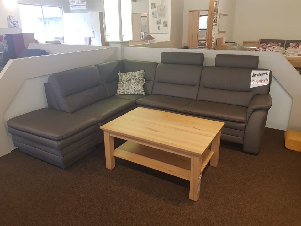 L-förmiges Sofa in einem dunklen Farbton mit Kopfstützen