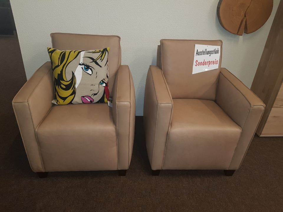 zwei beigefarbene quadratische Sessel