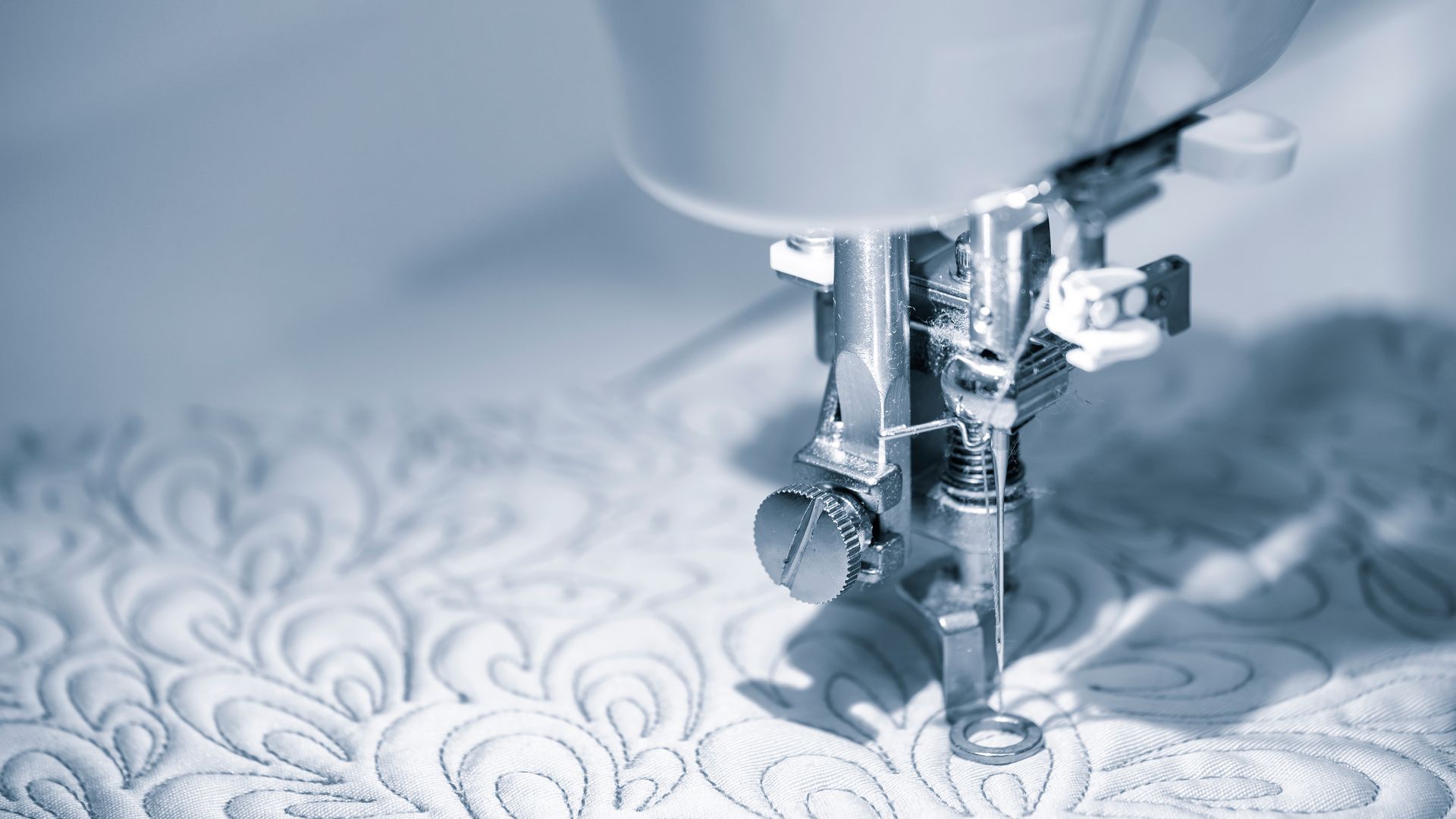 Aiguille de machine à coudre pour créer un motif floral sur du tissu.