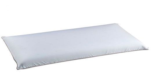 Una almohada blanca reposa sobre una superficie blanca.
