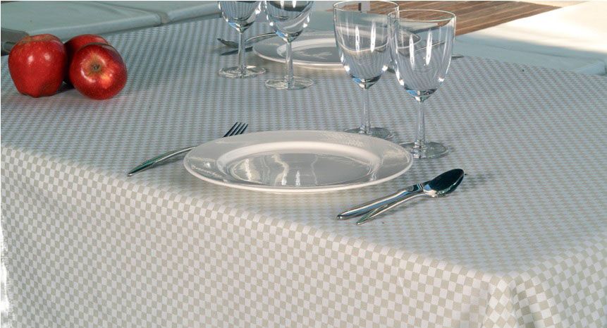 Una mesa con platos, vasos y manzanas encima.