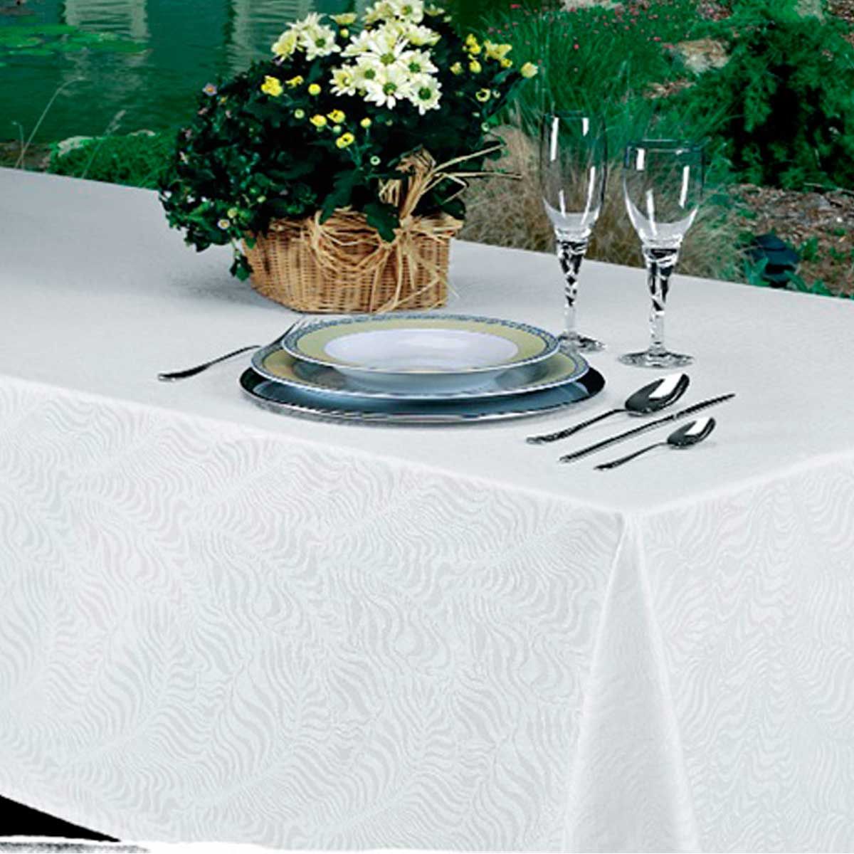 Una mesa con platos y vasos y una cesta de flores.