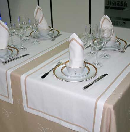 Una mesa con platos, tazas, vasos y servilletas sobre ella.