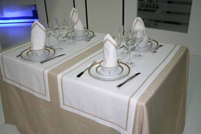 Dos mesas con platos, servilletas, vasos y cubiertos sobre ellas.