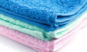Un primer plano de una pila de toallas de colores sobre un fondo blanco.