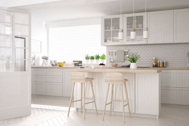 helle Küche im skandinavischen Stil mit Theke und Barhockern, weißen Schränken und Hängelampen