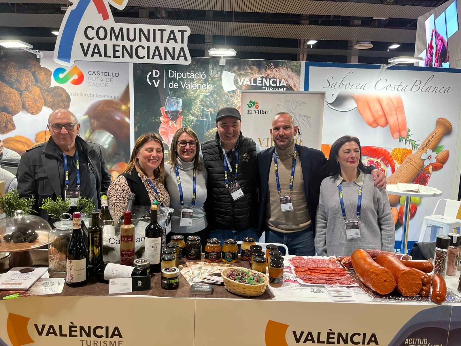 Un grupo de personas posa para una fotografía frente a una mesa con comida.