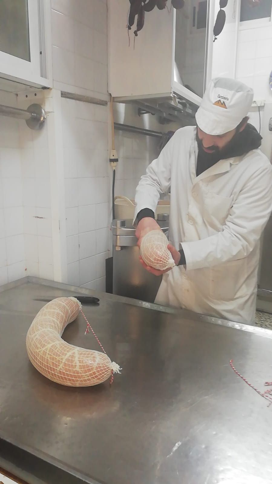Un hombre está haciendo una salchicha en una cocina.