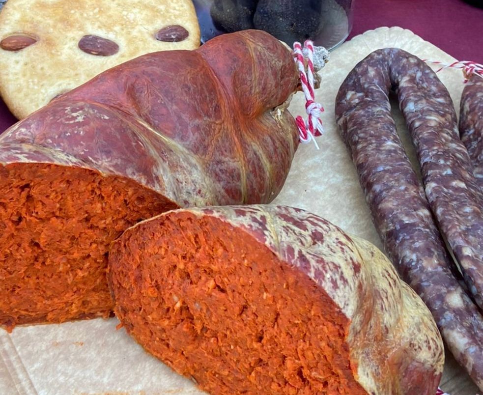 Un montón de salchichas y pan están sobre una mesa.