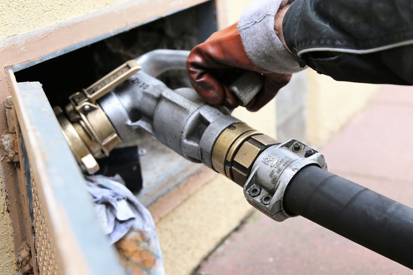 Una persona está bombeando gasolina a una manguera.