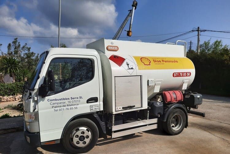 Un camión cisterna blanco y amarillo está estacionado en un estacionamiento.