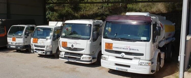 Una fila de camiones estacionados uno al lado del otro en un estacionamiento.