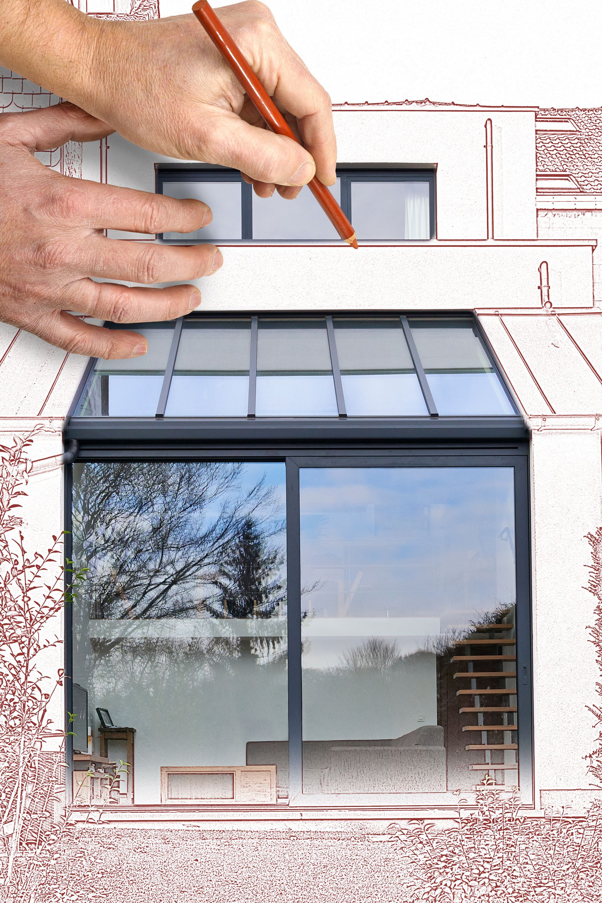 Des mains dessinent au crayon le plan d'une fenêtre et d'une façade de maison sur une photo de bâtiment.