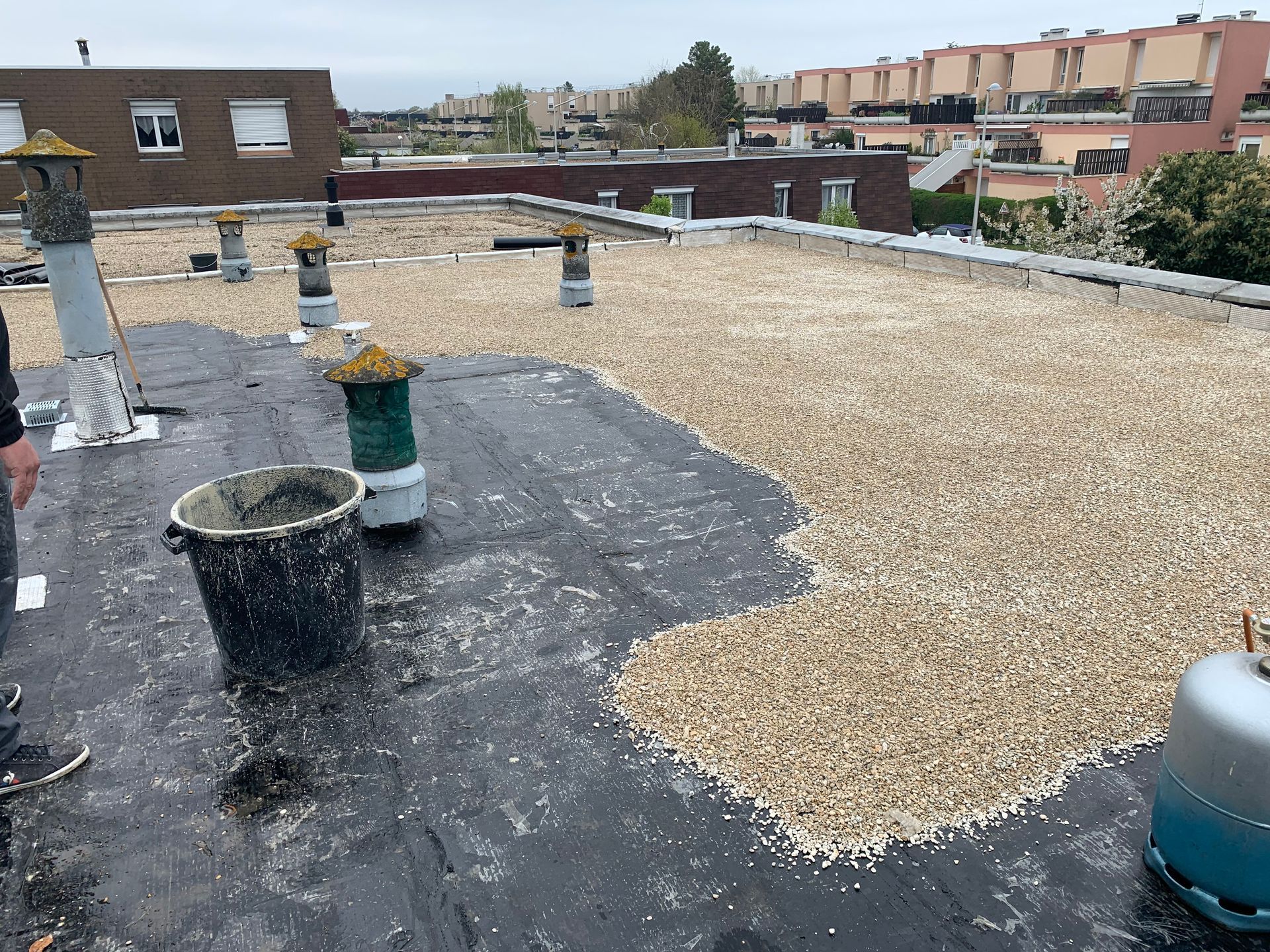 Application de gravillons sur toiture-terrasse