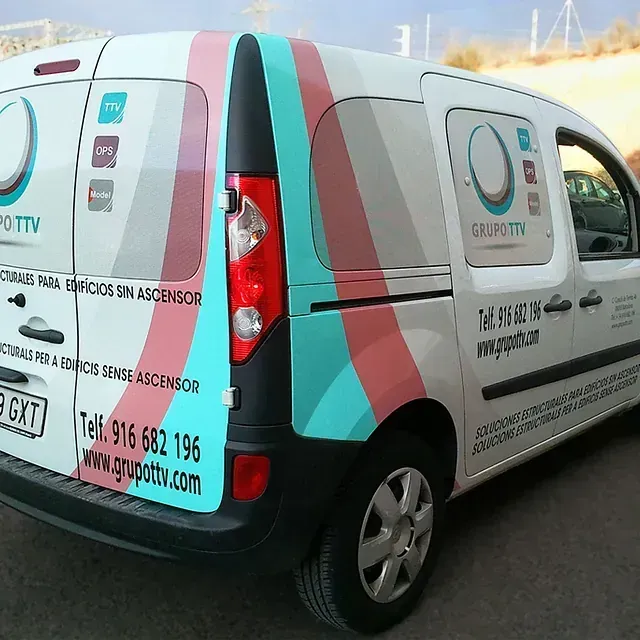 Furgoneta de servicio blanca con el logotipo de GrupoTTV y franjas de colores. El texto incluye información de contacto y los servicios que ofrece.