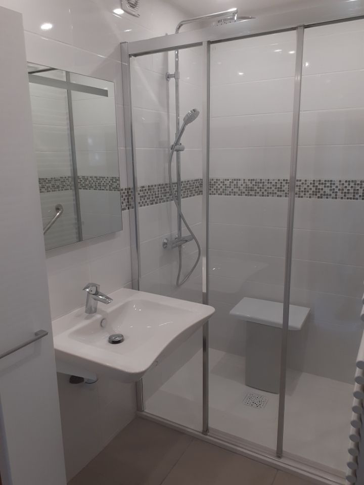 Salle de bains avec évier blanc et douche