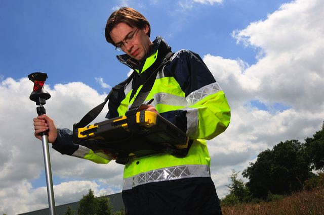 Géomètre-expert réalisant un relevé sur le terrain
