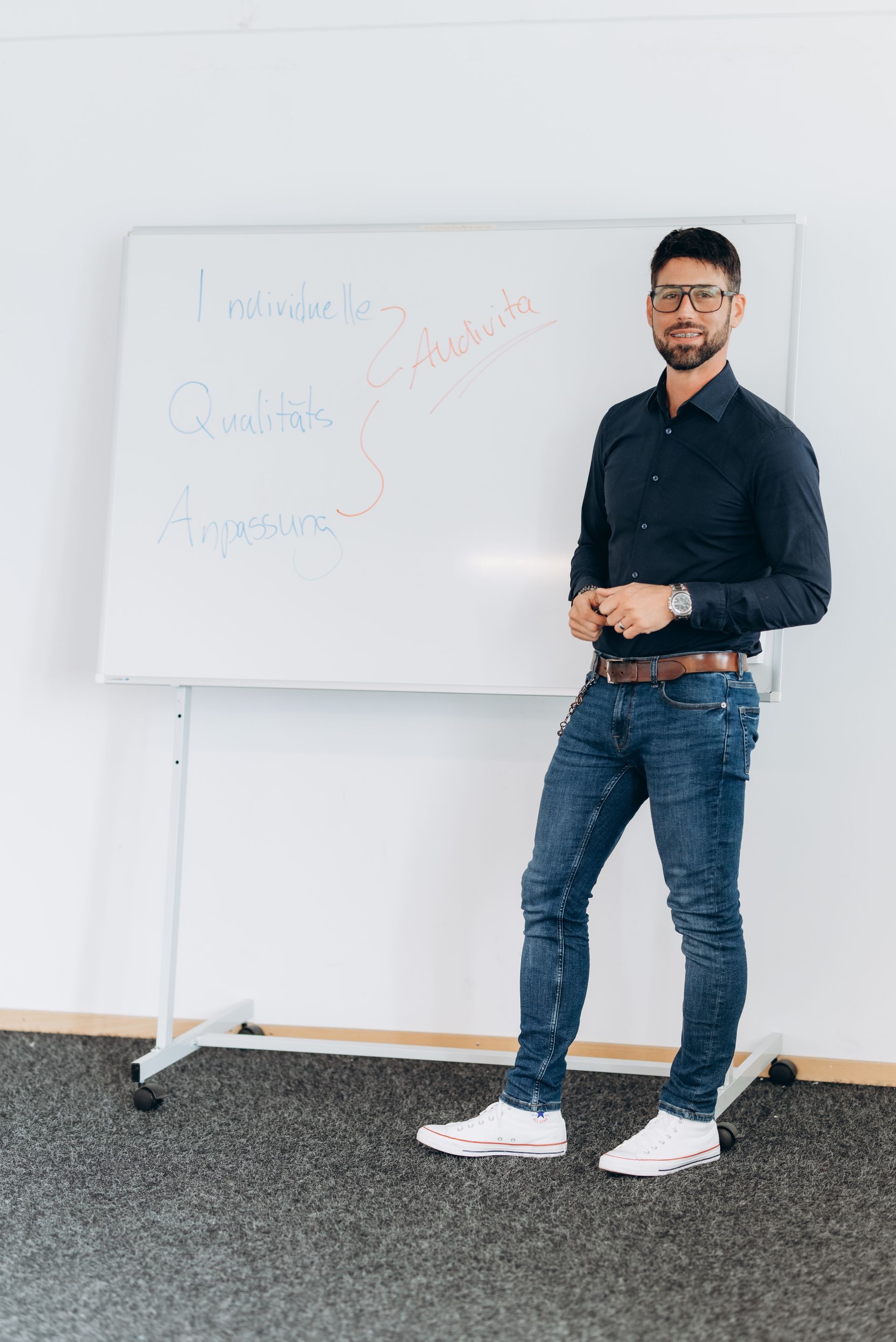 Eine Person unterzieht sich einem Hörtest. Eine andere Person untersucht ihr Ohr mit einem Instrument. Heller Raum.