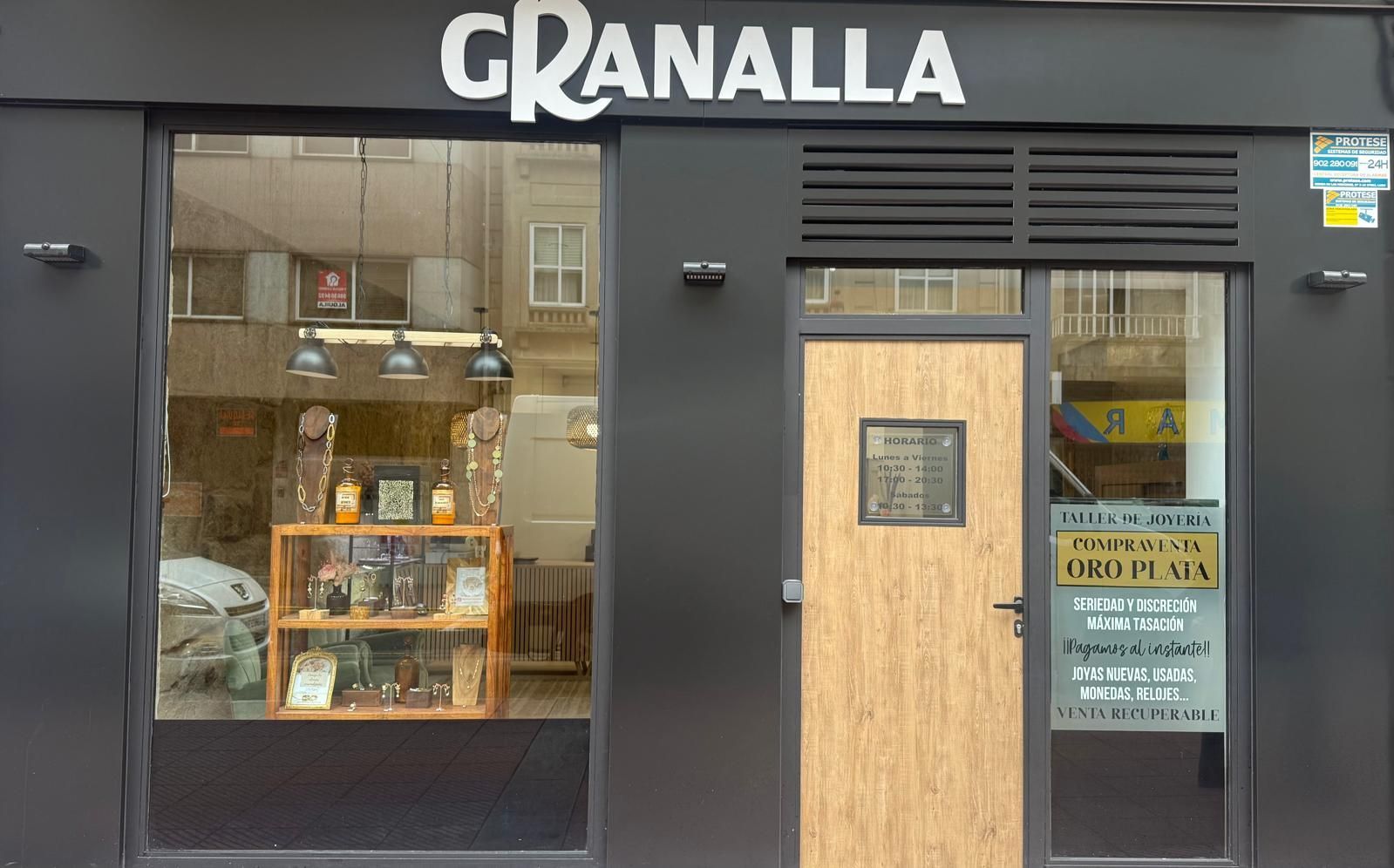 Un escaparate con un cartel que dice granalla taller de bisuteria.
