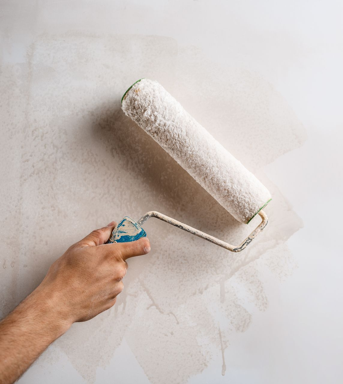 Un rouleau pour peindre un mur blanc.