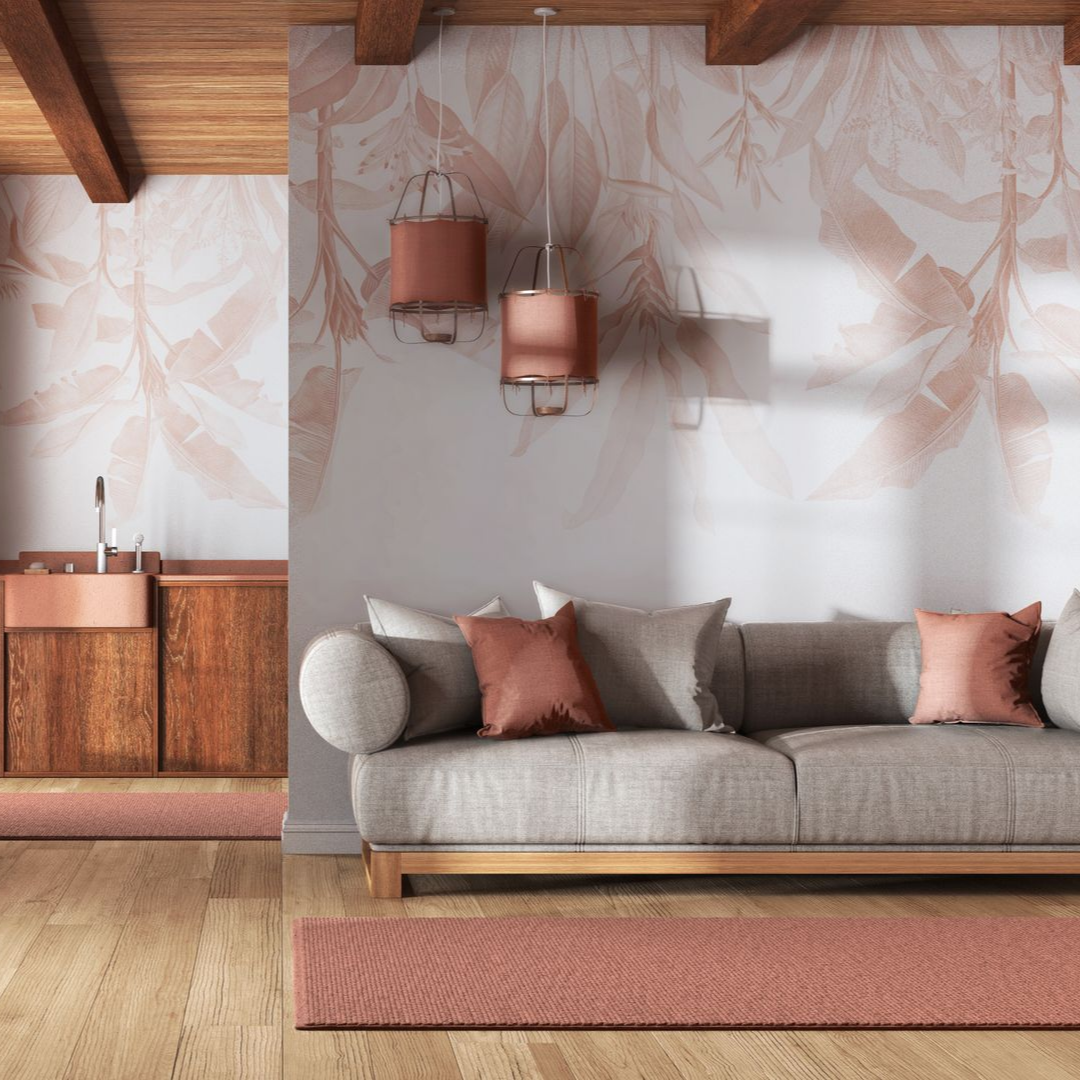 Un salon chaleureux avec un canapé gris, des coussins aux tons cuivrés, des suspensions assorties et un papier peint à motifs botaniques.