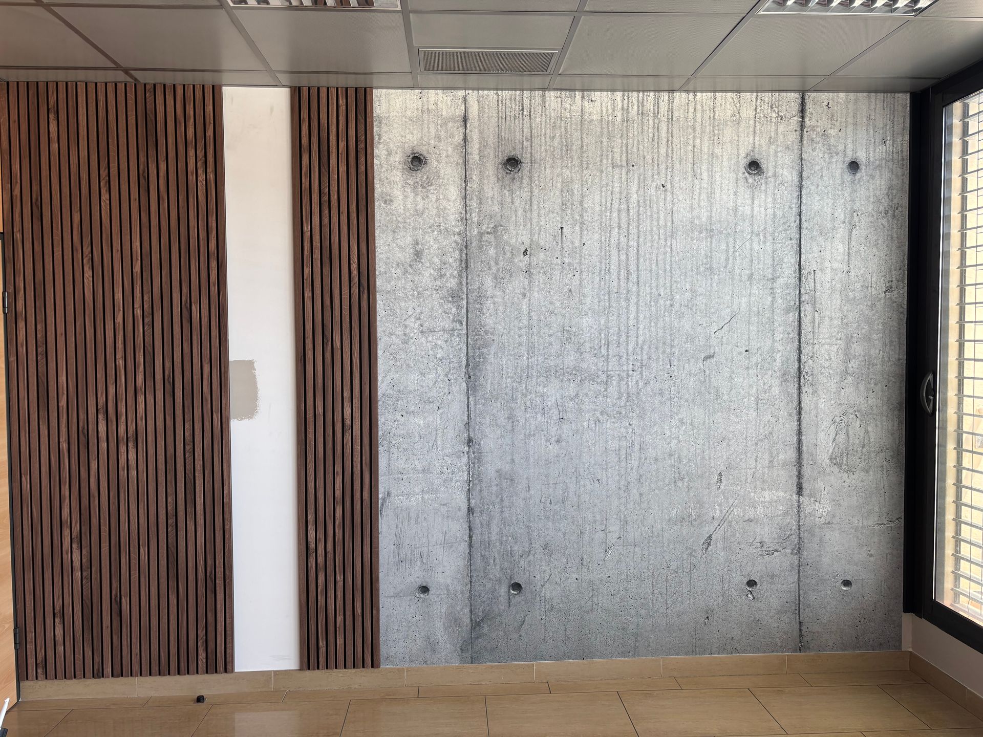 Un lit avec des oreillers texturés et une couverture à motifs, adossé à un mur orné d'une fresque murale fantaisiste représentant une forêt verte.