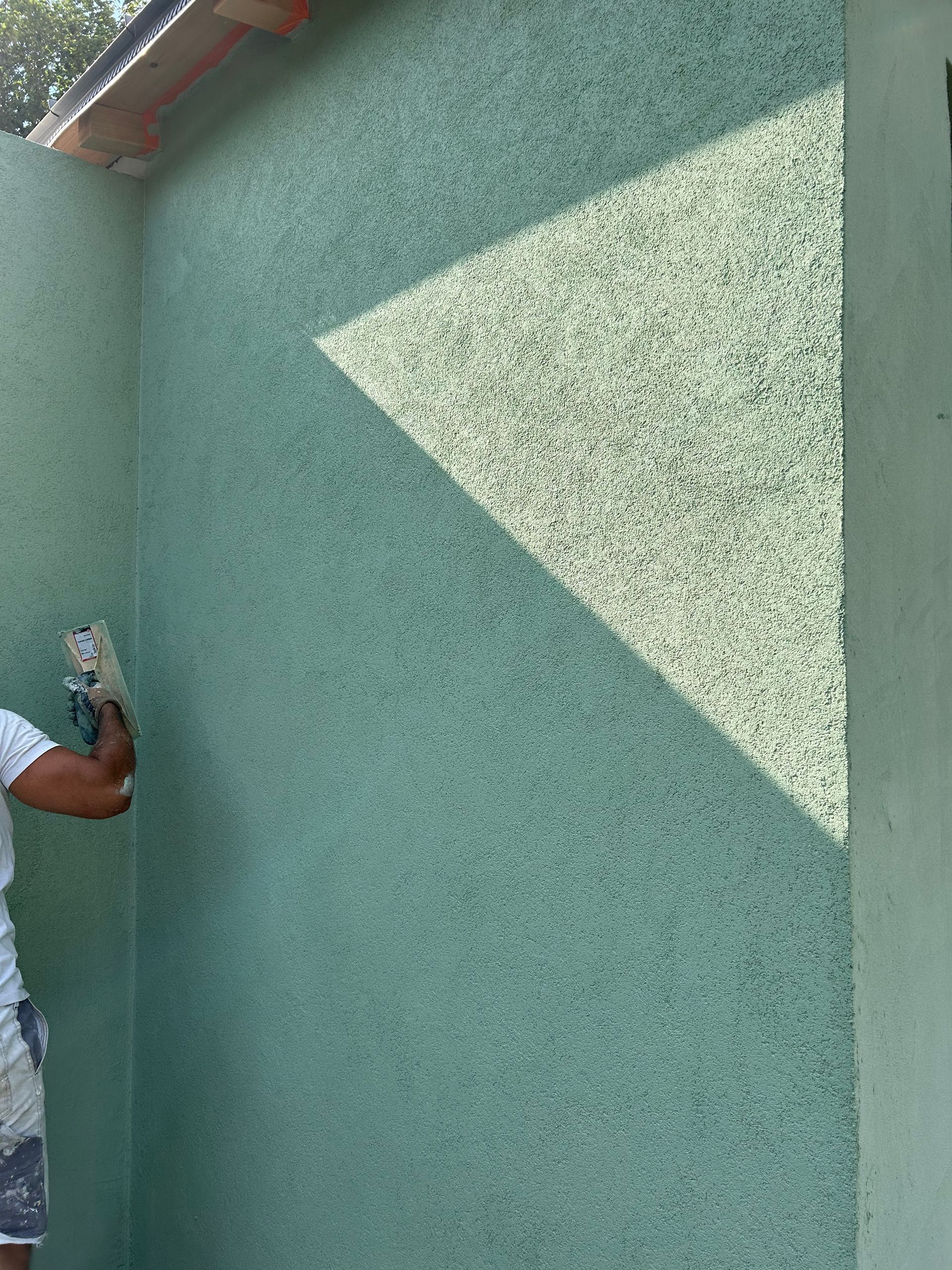 Deux arches dans un salon avec une peinture verte aux murs.