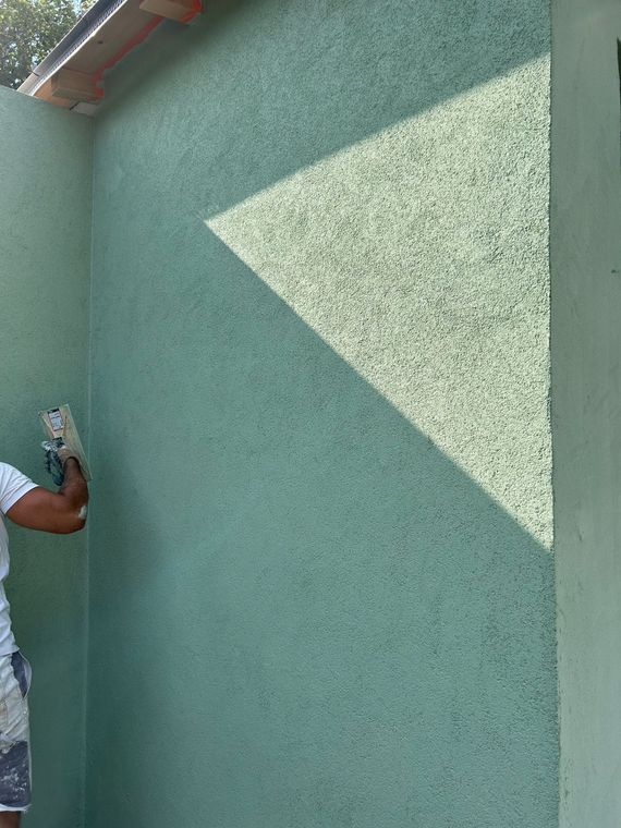 Deux arches dans un salon avec une peinture verte aux murs.