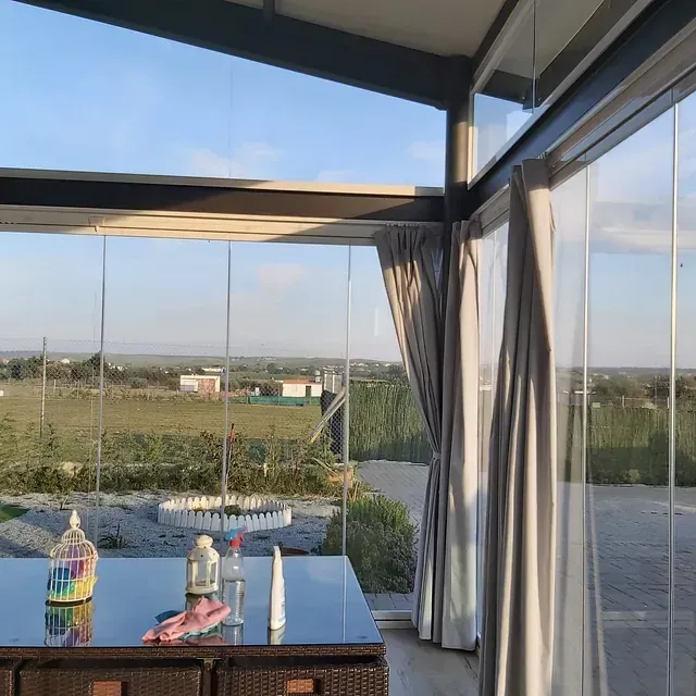 Una habitación con una mesa y vista a un campo.