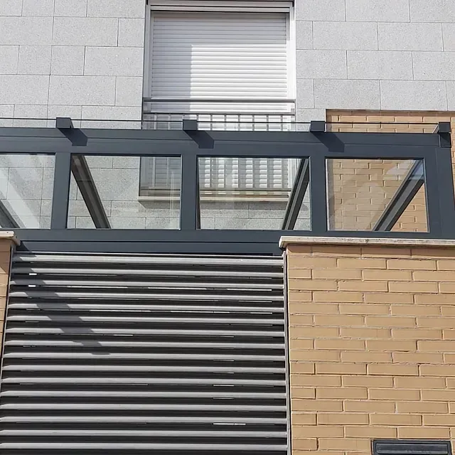 Un edificio de ladrillo con balcón y techo de cristal.