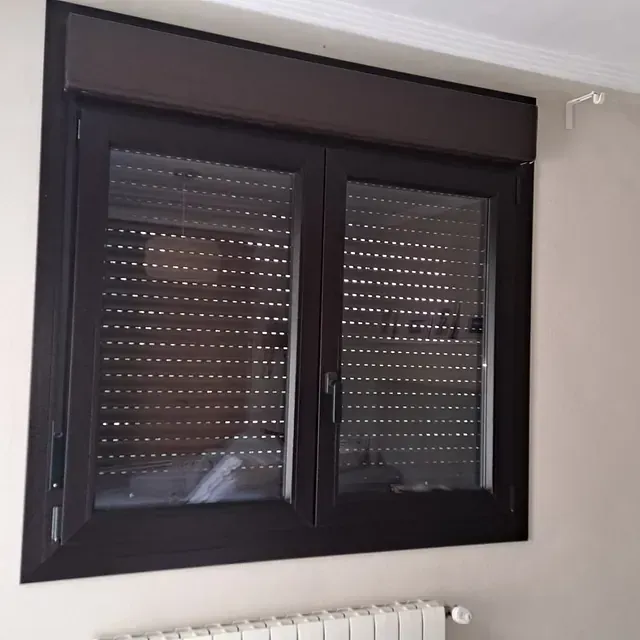 Una ventana con contraventanas está al lado de un radiador.