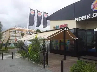 Un restaurante Burger King con un gran toldo sobre la entrada.