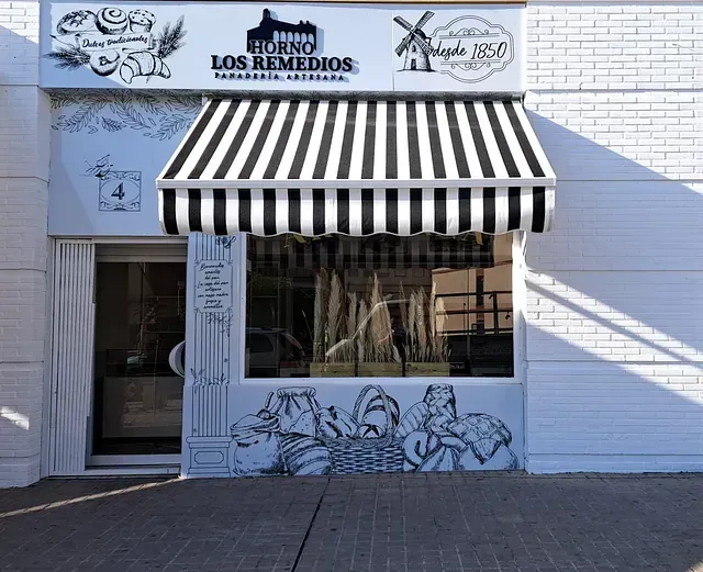 Un escaparate con un toldo de rayas que dice los remedios