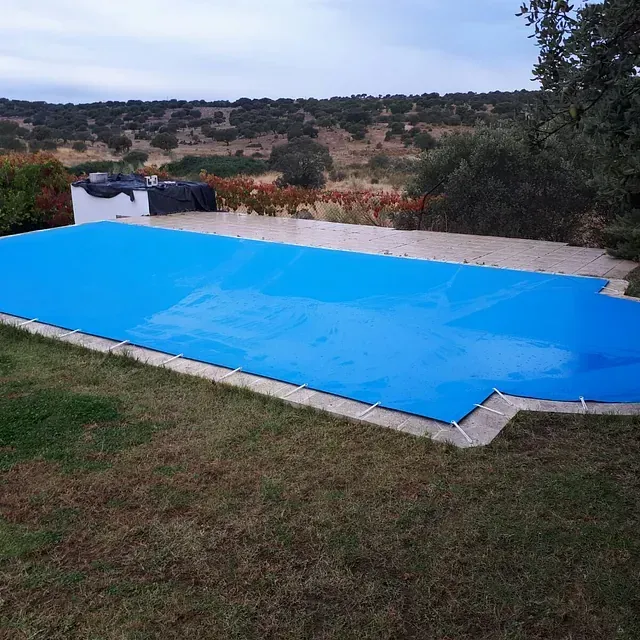 Una gran piscina con una cubierta azul.
