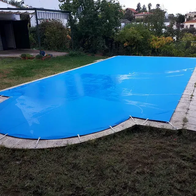Una gran piscina con una cubierta azul.