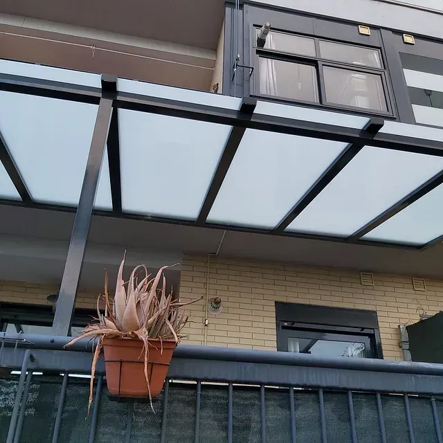 Una planta en maceta cuelga de la barandilla de un balcón.