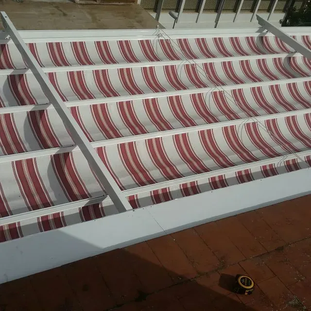 Un toldo de rayas rojas y blancas en un tejado.