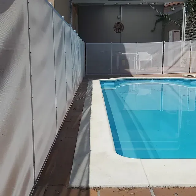 Una gran piscina con una valla blanca alrededor.