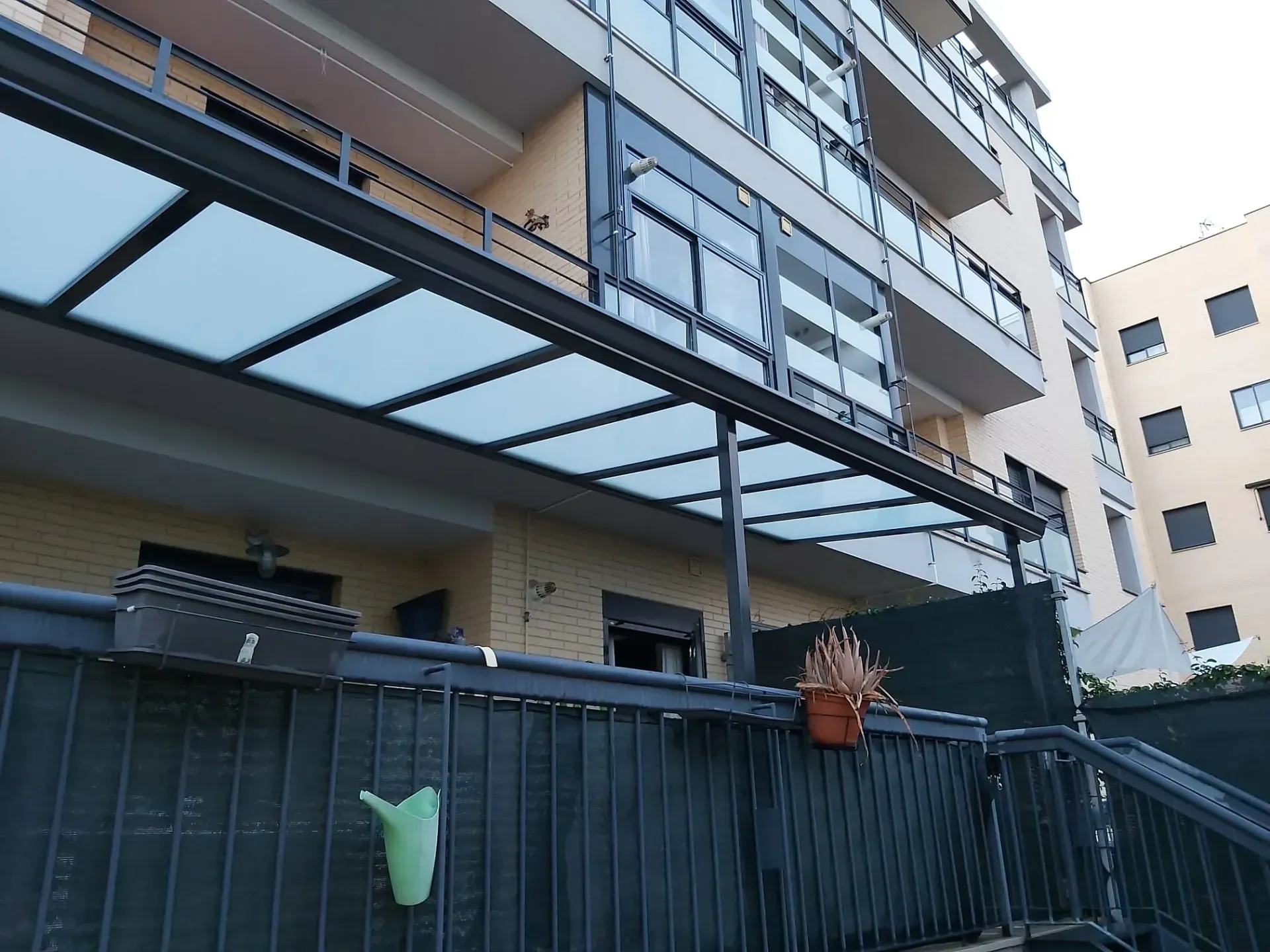 Un balcón con un dosel encima y plantas en macetas.