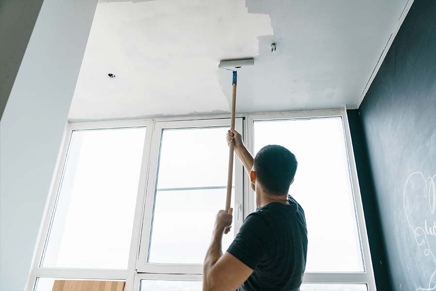 Un homme en train de peindre un plafond
