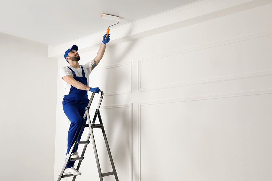 Un homme en train de peindre un plafond