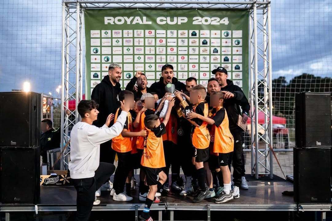El equipo de fútbol levanta el trofeo en el escenario tras la victoria en la Royal Cup 2024.