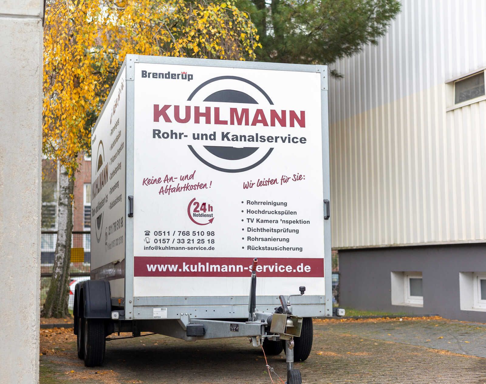 Ein Kuhlmann Rohr- und Kanalservice-Anhänger steht vor einem Gebäude